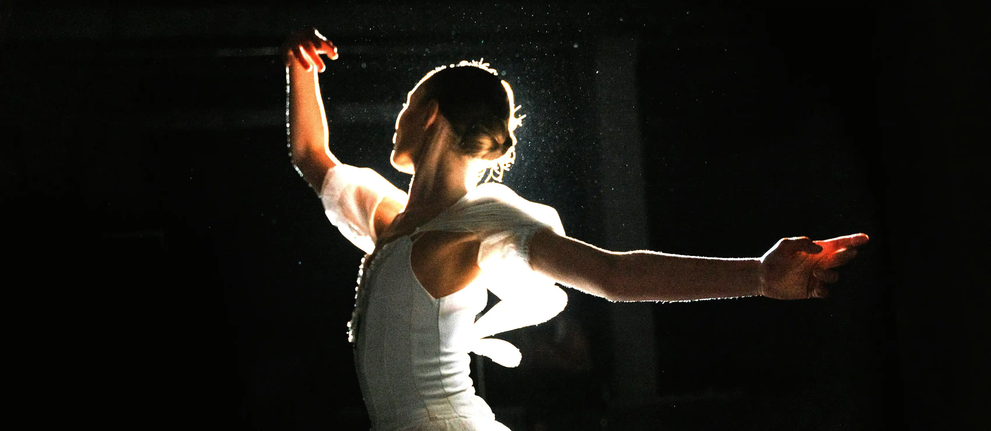 Ballerina dancing against black background