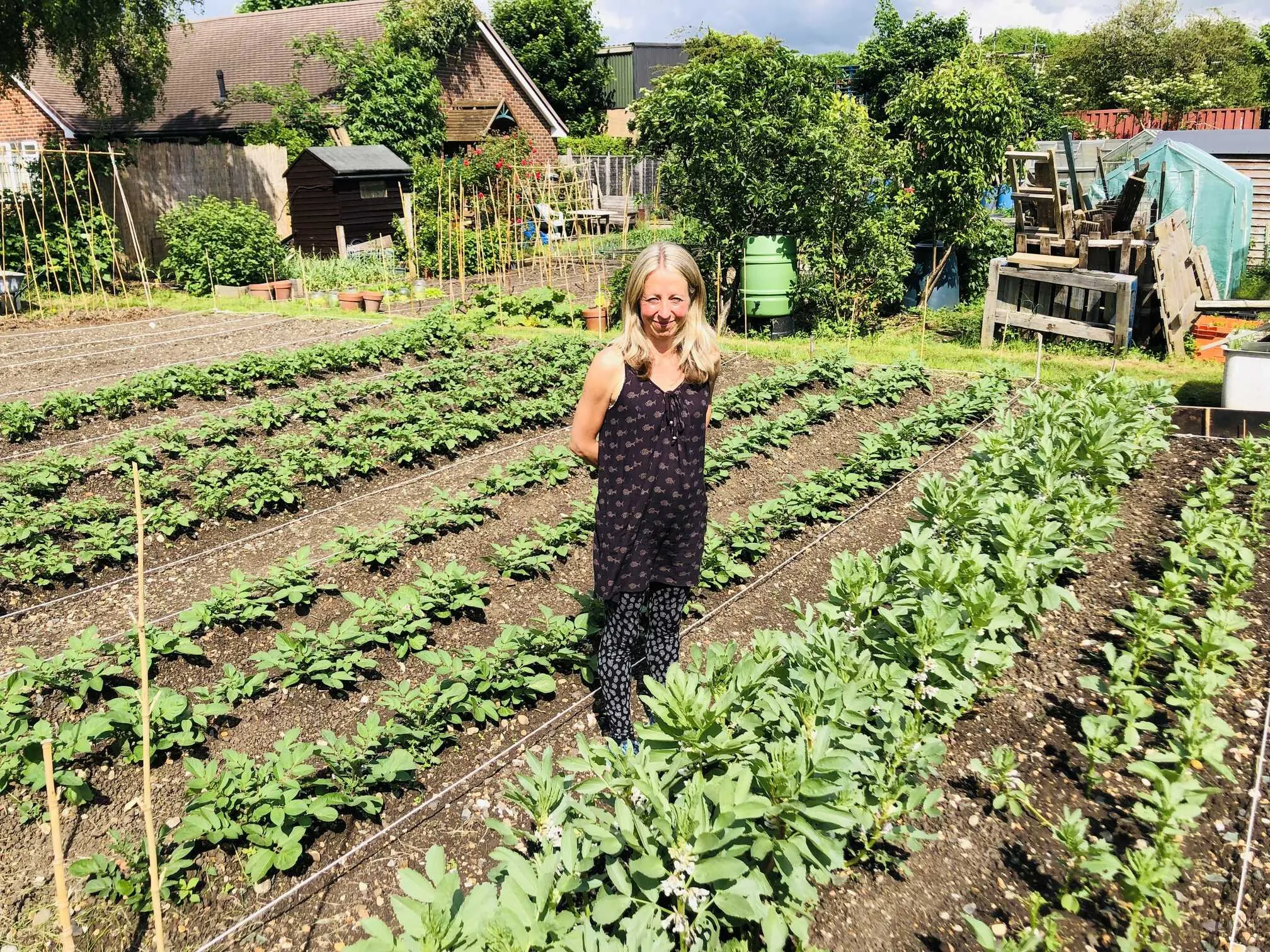 Vicky Salter standing next to broad beans and potatoes.