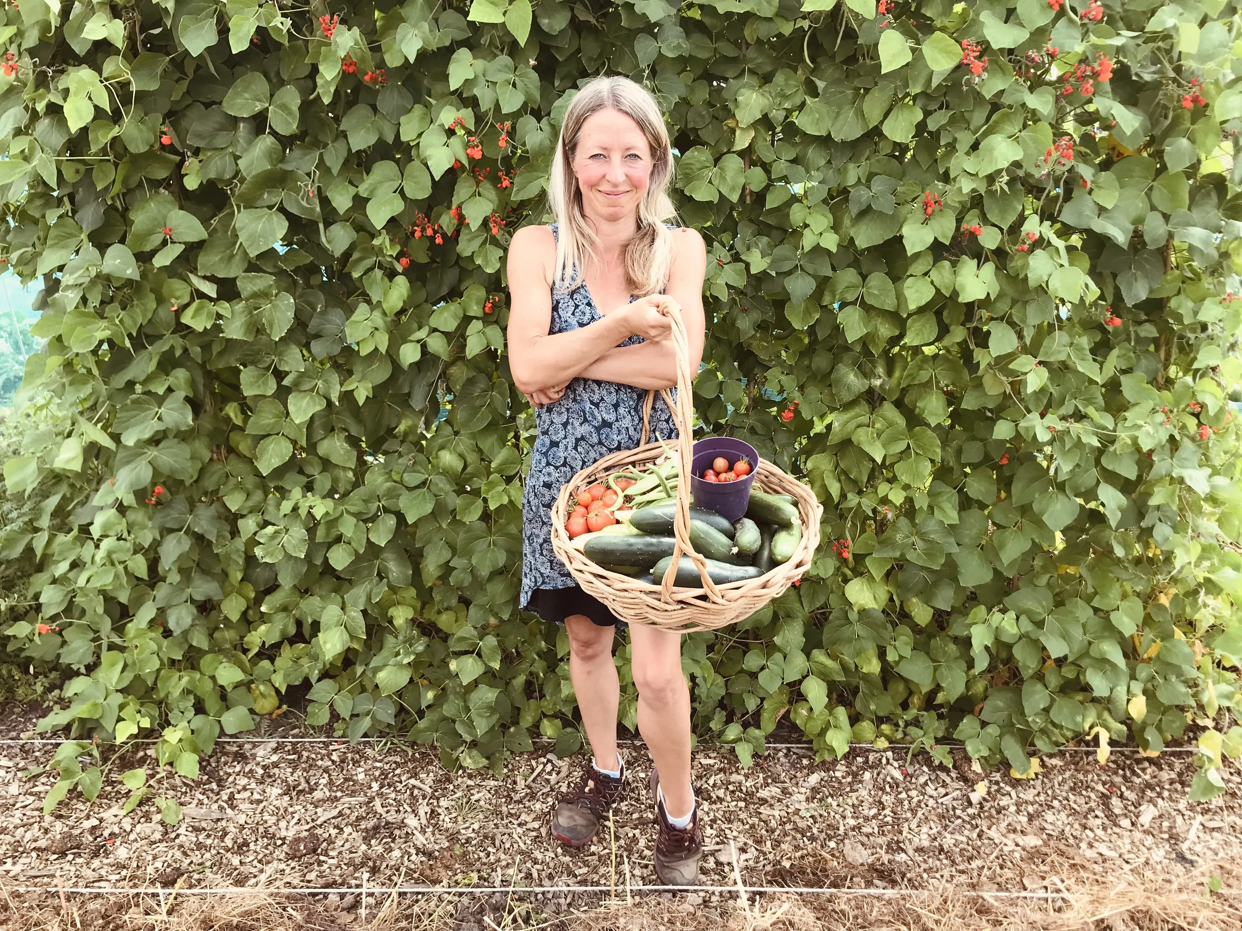 Vicky Salter holding a basket of fresh vegetables.