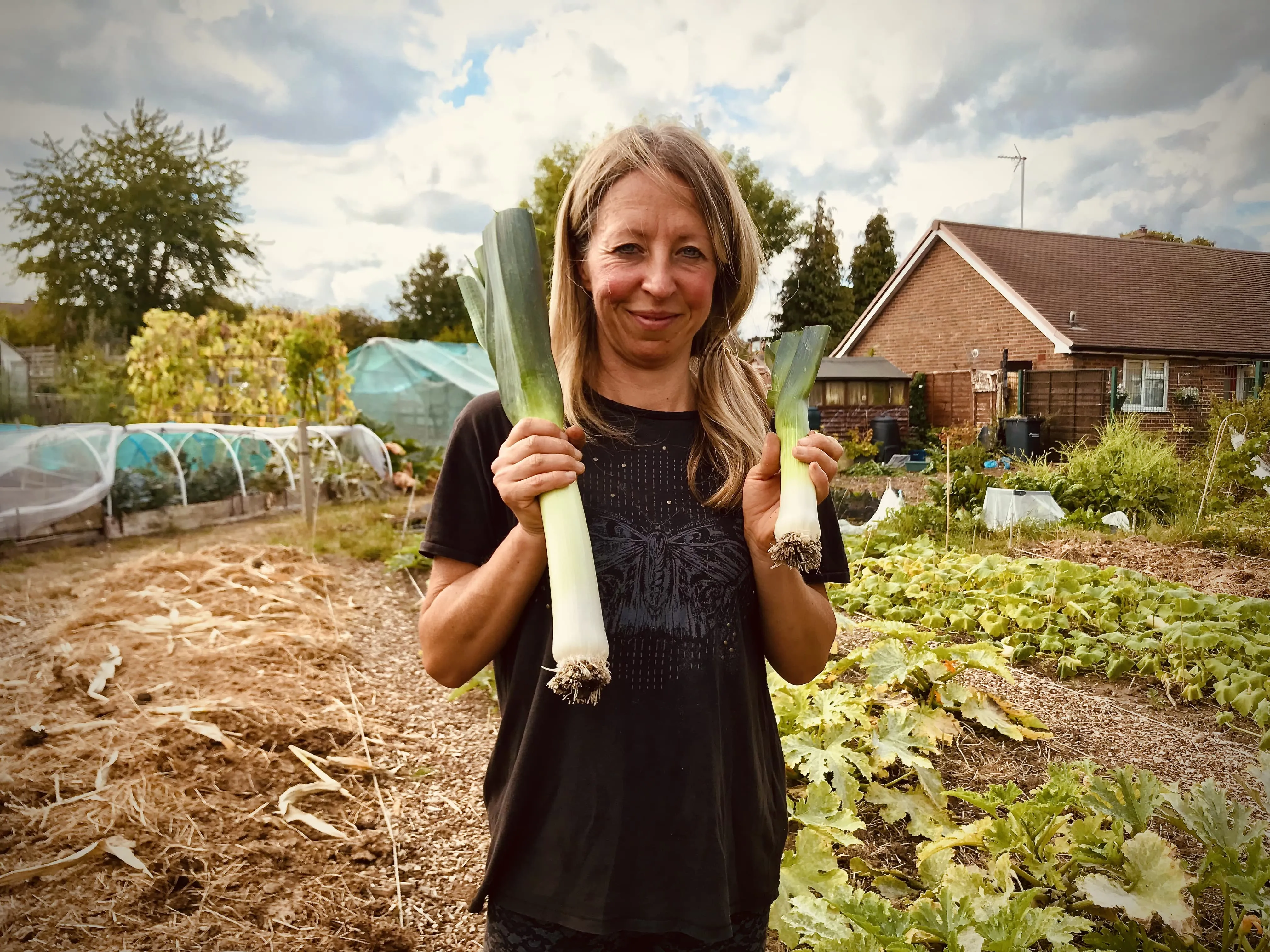 Vicky Salter holding leeks on the allotment.