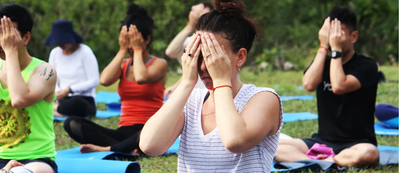 Outdoor yoga class meditating.