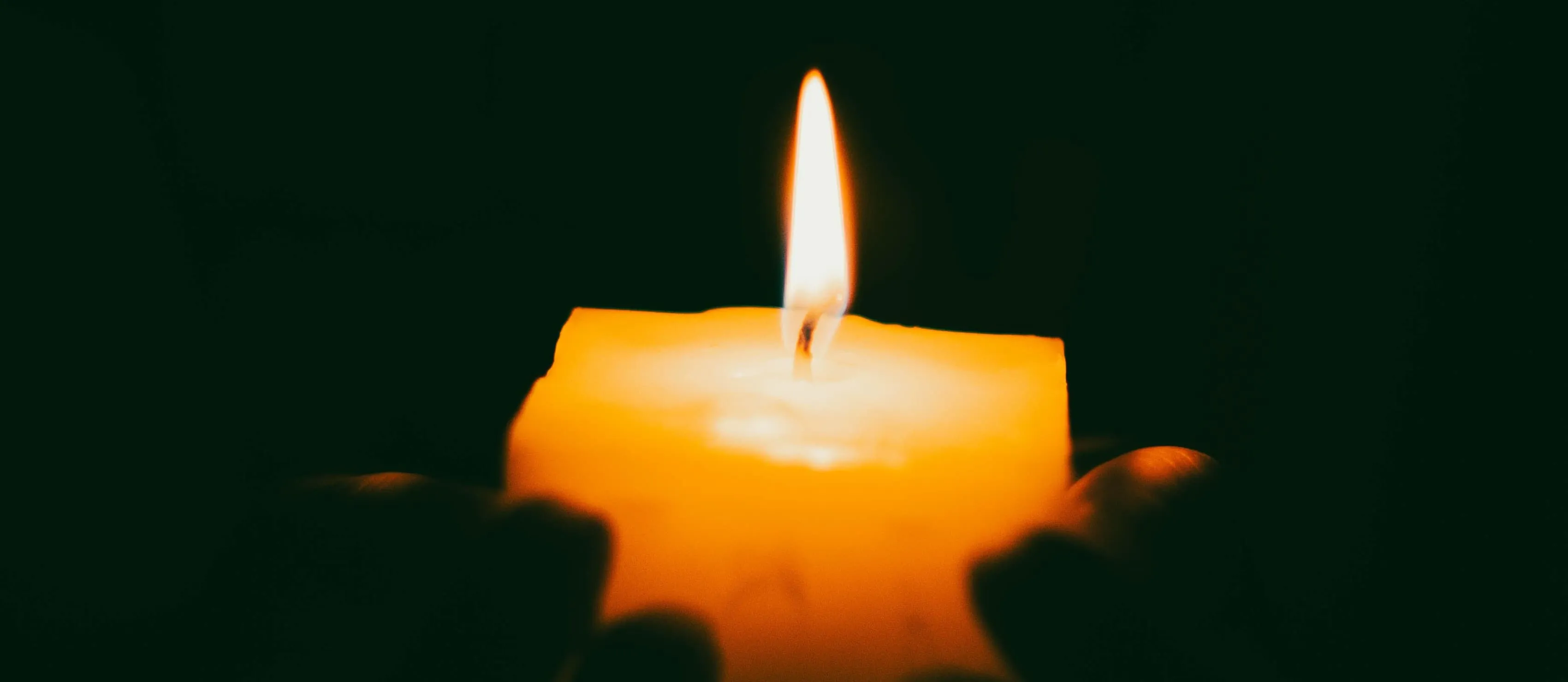 Hands holding a candle.
