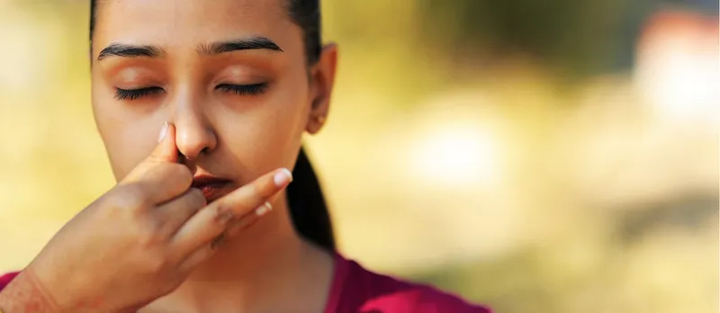 Woman practising alternate nostril breathing.